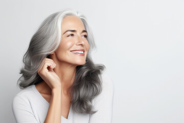 Portrait of a beautiful ageing mature woman with long grey hair. Healthy face and skin care beauty, cosmetics, cosmetology concept. - obrazy, fototapety, plakaty