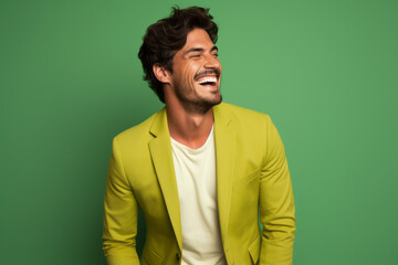 Fototapeta premium Ultra handsome man, model, smiling and laughing, wearing bright clothes. Bright solid green and yellow isolated background.