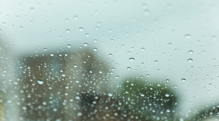 Raindrops on windowpane during a rainy day, capturing the tranquility and melancholy of nature's...