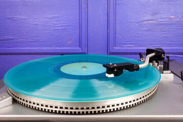 Close up of vintage turntable record player with turquoise vinyl