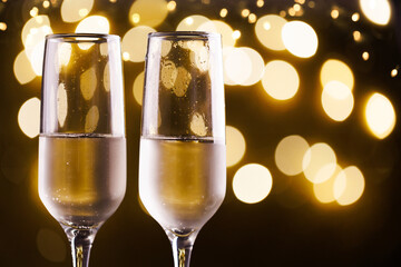 Two New Year's glasses of champagne with highlights on a colored background