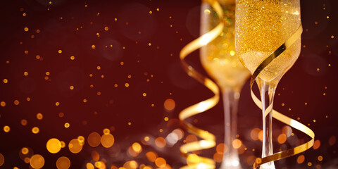 Two New Year's glasses of champagne with highlights on a colored background