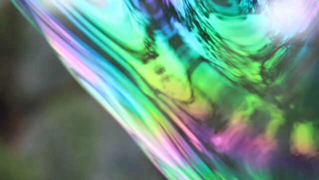 Slow motion footage of a giant, colorful soap bubble floating in air