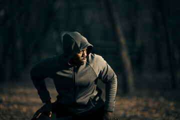 Young fit man stretching and warming up before a workout in a outdoor park