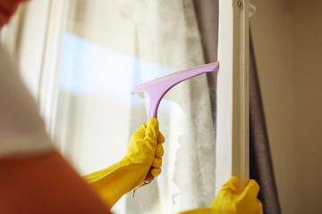 Detail on washer hand in yellow glove hold cleaning squeegee and clean dirty office window. Cleaning service concept banner or wide