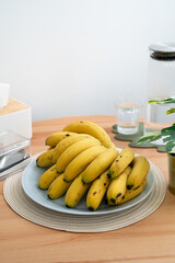 A bunch of fresh banana on a dining table in a modern kitchen.