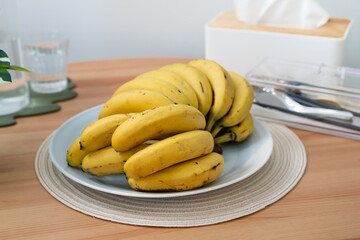 A bunch of fresh banana on a dining table in a modern kitchen.