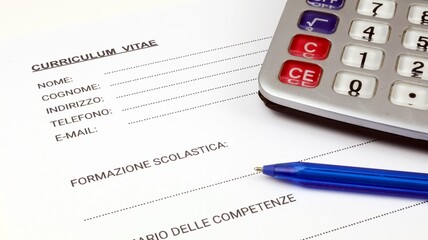 Fototapeta premium Curriculum Vitae una forma italiana, curriculum vitae vuoto con una penna e una calcolatrice.