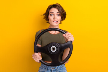 Photo of nervous woman wear trendy t-shirt hold steering wheel biting lips staring at accident isolated on yellow color background