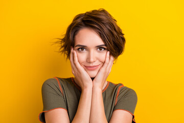 Photo of pretty adorable lady wear khaki t-shirt smiling arms cheeks isolated yellow color background