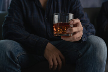 Businessman in suit drinking whiskey celebrating Close-up shot of alcoholic drink A man in a formal suit toasts with a glass of whiskey.