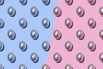 Seamless Pattern of sparkly chocolate foil eggs on pink and blue background.