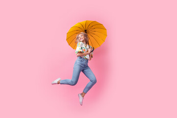Full body image of careless young woman blonde wavy hair jumping high have fun with umbrella look...
