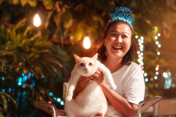Asian woman celebrates New Year with her cat with happiness.Heartwarming relationships between people and their beloved pets. 
