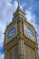 Big Ben clock set against partially cloudy blue sky. London Landmark.