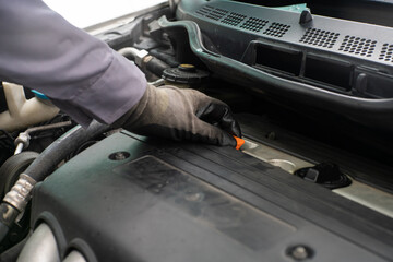Mechanic man hand checking engine oil refill car maintenance close up