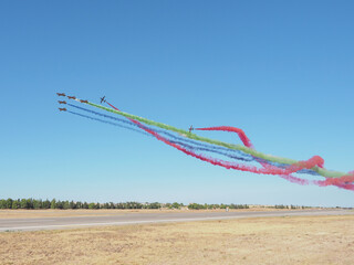 Group of fighter jet airplane with a trace of colorful smoke against sky