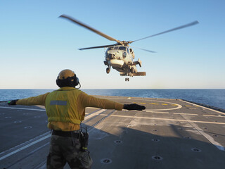 Navy helicopter landing on warship