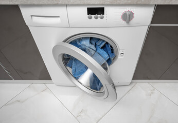 Washing machine overflowing with clothes. Wrong wash.