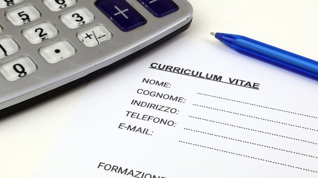 Curriculum Vitae una forma italiana, curriculum vitae vuoto con una penna e una calcolatrice.
