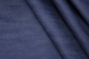 Cotton fabric denim blue background. Draped soft cotton jeans blue fabric texture.