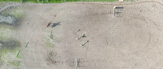 Foto auf Alu-Dibond Aerial view of three horsemen. A riding field with fence and obstacles to train horses. In this sports facility, tournaments and horse racing courses are organized. The sports center is in the nature. © netsay