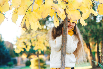 Happy child on the walk in autumn park. Beautiful autumn season.