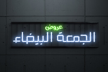 Translation White Friday neon sign on concrete wall with Arabic font 