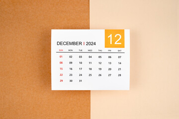 A December 2024 calendar page on yellow background.