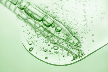 Liquid pipette serum green gel on green colored mirror background
