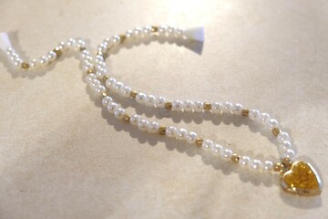 pearl necklace with gold beads and a heart