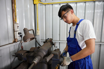 factory worker or technician checking lathe machine in factory