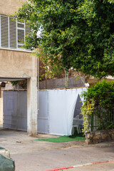 Jewish festival of Sukkot in Israel. Traditional sukkah with handmade decorations near the building on the street. 