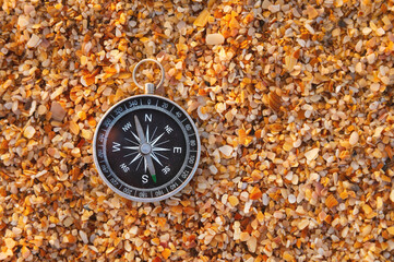 compass on sea sand and place for text. close up of navigation device on sandy beach without...