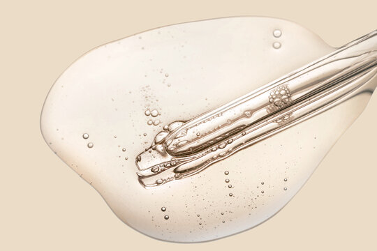 Liquid pipette serum gray gel on light berry colored mirror background