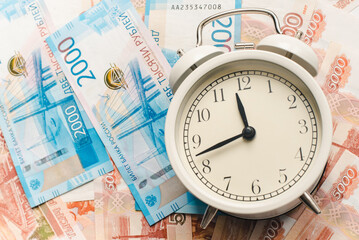 Time to pay taxes. Alarm clock and Russian banknotes. Time is money.