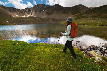 Man traveler walking along beautiful views of mountains and lakes. A woman goes on a trip and walks in the mountains. Beautiful view
