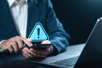 Maintenance concept. Businessman using smartphone with triangle caution warning sign  for notification error. System failure and security issues. - obrazy, fototapety, plakaty