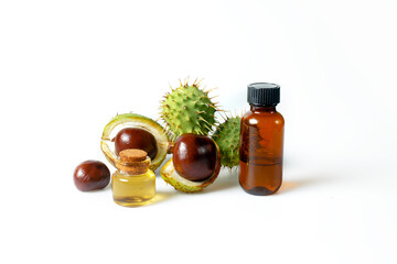Autumn horse chestnut with peel, bottles with oil and chestnut extract on a white background - 657690958