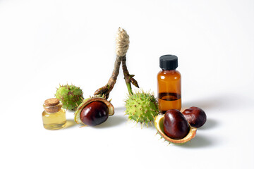 Autumn horse chestnut with peel, bottles with oil and chestnut extract on a white background - obrazy, fototapety, plakaty