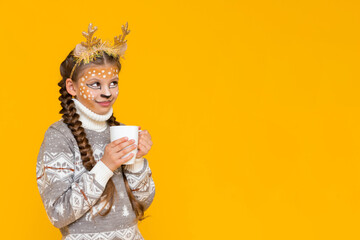 A child with deer antlers holds a cup of hot cocoa and looks at your advertisement. A little girl...