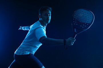 Padel tennis player. Padel open tour. Man athlete with paddle tenis racket and ball on blue...