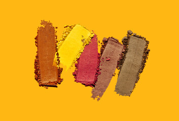 Cosmetic eye shadow swatch palette set isolated on yellow orange background