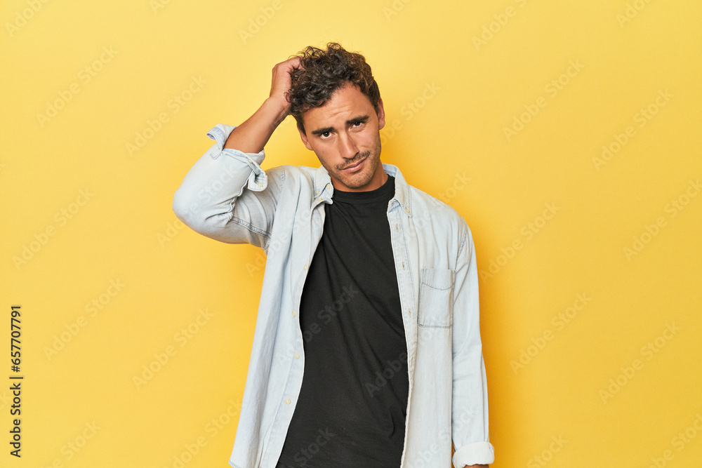 Wall mural Young Latino man posing on yellow background tired and very sleepy keeping hand on head.