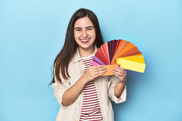 Chic designer woman with a color palette on blue background