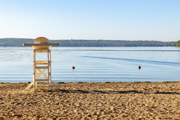 A white lifeguard station on a beach and calm water.
