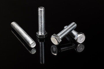 Silver bolts on a reflective, black background