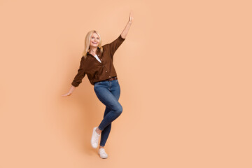 Fototapeta na wymiar Full body length photo of young funky woman dancing careless wear trendy outfit chill atmosphere isolated on beige color background