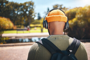 Back, music headphones and student outdoor, listening to audio or streaming sound online. Radio,...