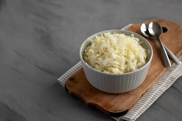 Homemade German Sauerkraut in a Bowl on a gray background, side view. Copy space.